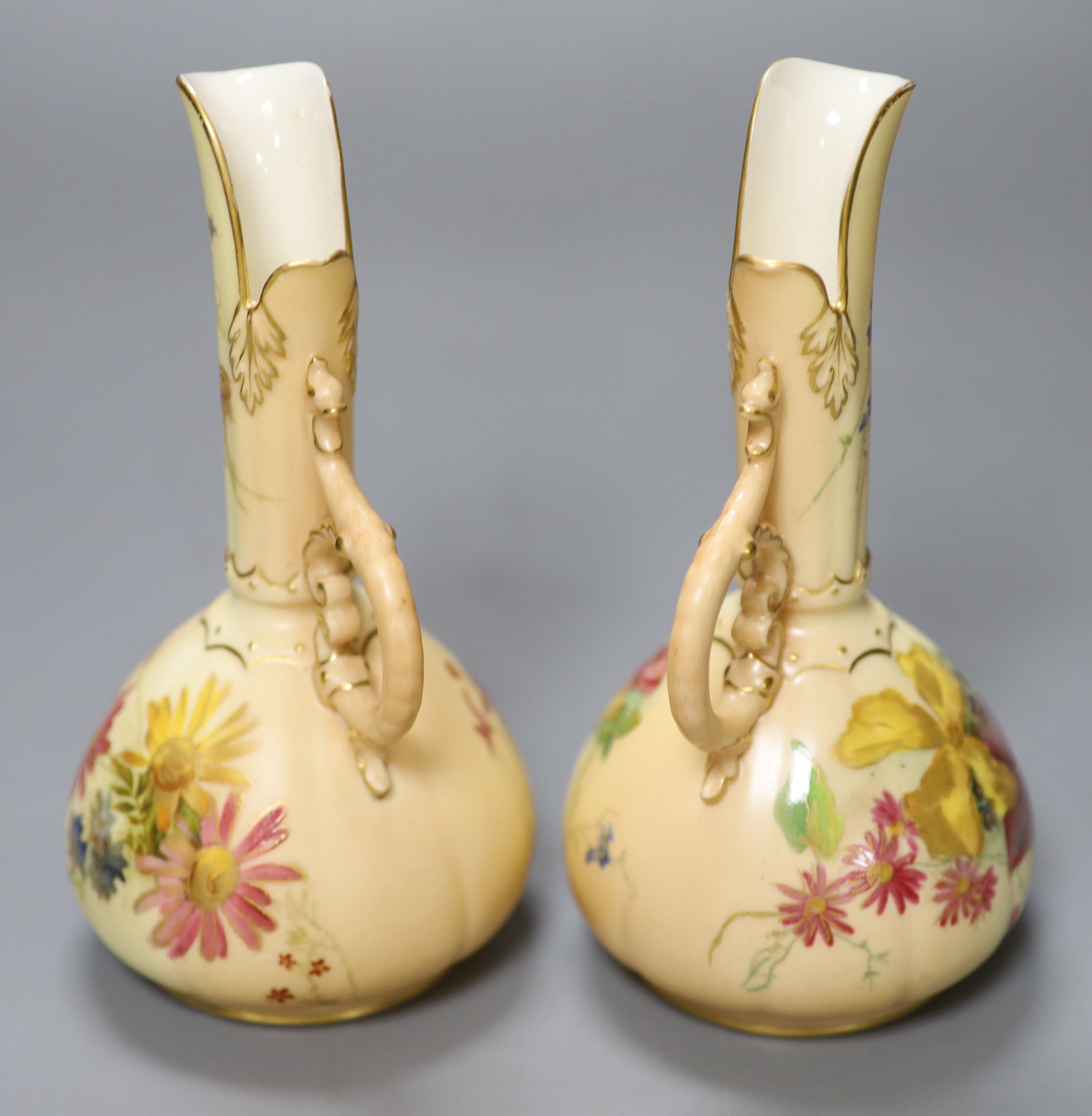 A pair of Royal Worcester blush ivory ewers painted and gilded with flowers, green mark, date code 1900, height 15cm